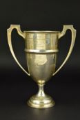 A GEORGE V TWIN HANDLED TROPHY CUP, on a short pedestal to a stepped circular base, engraved