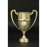 A GEORGE V TWIN HANDLED TROPHY CUP, on a short pedestal to a stepped circular base, engraved