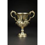 A VICTORIAN SILVER TWIN HANDLED TROPHY CUP, of lobed baluster form, gilt interior, repousse