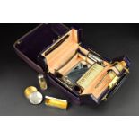 A GEORGE V TRAVELLING VANITY CASE RETAILED BY J.C. VICKERY, purple canvas outer cover with velvet