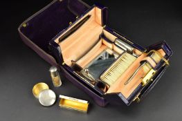 A GEORGE V TRAVELLING VANITY CASE RETAILED BY J.C. VICKERY, purple canvas outer cover with velvet