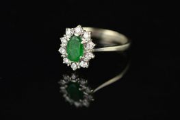A LATE 20TH CENTURY 18CT WHITE GOLD EMERALD AND DIAMOND OVAL CLUSTER RING, oval mixed cut emerald