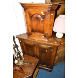 AN OAK TWO DOOR HANGING CORNER CUPBOARD, together with a small hanging corner cupboard, table lamp