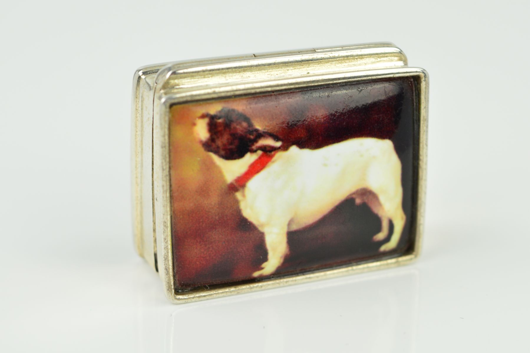 A PILL BOX of rectangular outline with a transfer print of a French bulldog to the front panel,