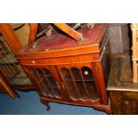 A REPRODUCTION MAHOGANY GLAZED TWO DOOR MUSIC CABINET, with a red tooled leather inlay top, width