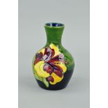 A SMALL MOORCROFT POTTERY BUD VASE, 'Hibiscus' pattern on green ground, impressed marks to base,