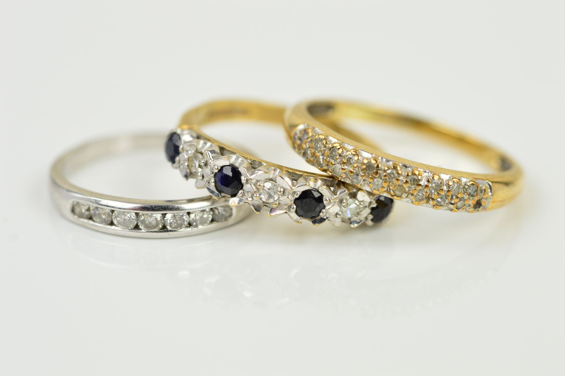 THREE MODERN GEM SET DRESS RINGS to include a 9ct gold pave diamond set eternity ring, ring size