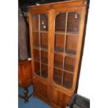 AN EARLY 20TH CENTURY OAK GLAZED TWO DOOR BOOKCASE, revealing adjustable shelving above double