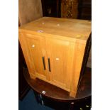 A LIGHT OAK TWO DOOR CUPBOARD, a glass three tier tv stand and a mirror (3)