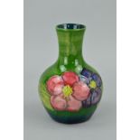 A MOORCROFT POTTERY BUD VASE, 'Clematis' pattern on green ground, impressed marks to base, height