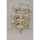 A GEORGE V SILVER THREE TIER CONDIMENT STAND, the frame holding three removable circular dishes with