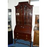 AN EDWARDIAN MAHOGANY BUREAU BOOKCASE, the flanked canted top above double astragal glazed doors,