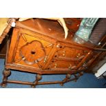 A 20TH CENTURY OAK PANELLED SIDEBOARD, the raised back with rope edging and foliate carving, flanked