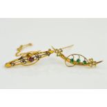 TWO EARLY 20TH CENTURY GOLD BROOCHES, the first designed as a curved tapered bar with applied floral
