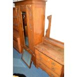 AN ARTS AND CRAFTS OAK TWO PIECE BEDROOM SUITE, comprising of a single mirror door wardrobe above