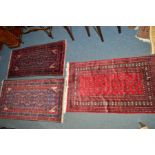 A 20TH CENTURY WOOLLEN TEKKE RUG, red ground, 154cm x 91cm, together with two similar red ground