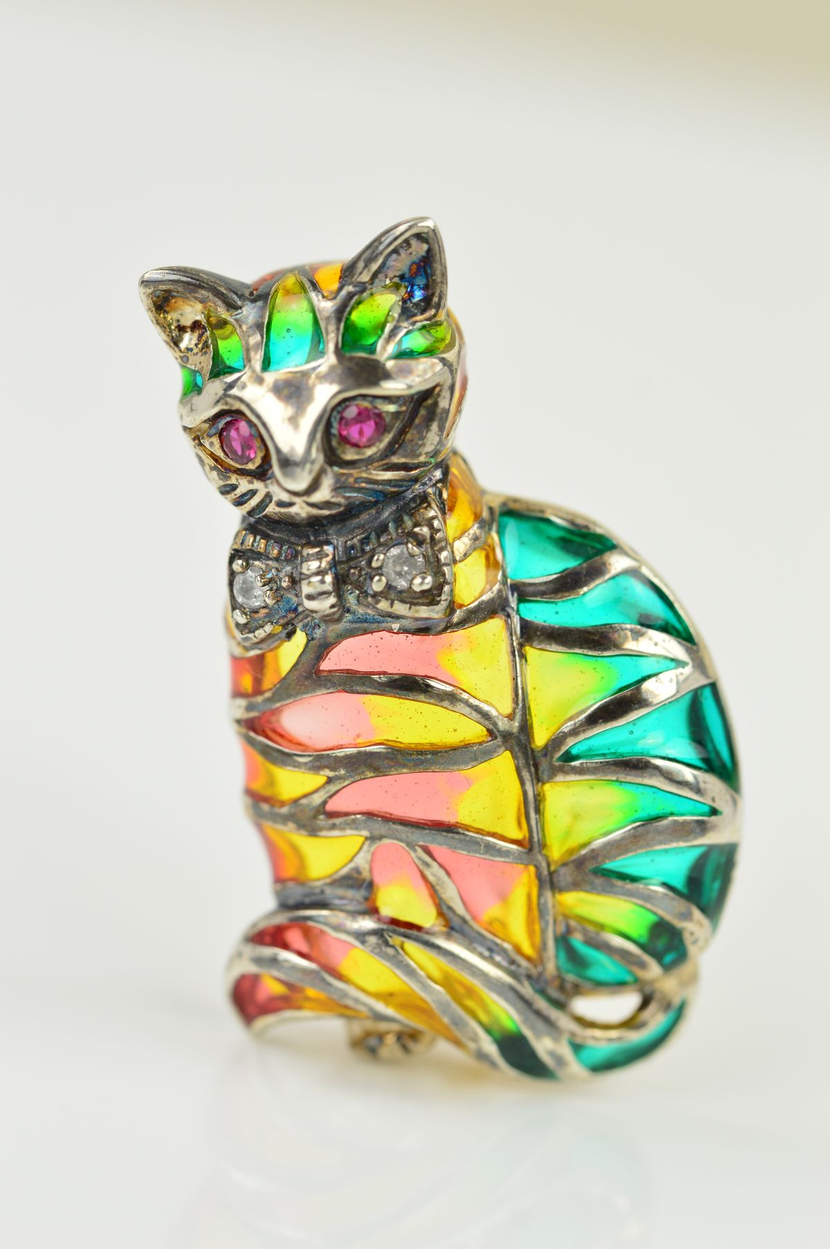 A GEM AND PLIQUE A JOUR CAT BROOCH, designed as a cat with ruby eyes, (possibly synthetic) diamond