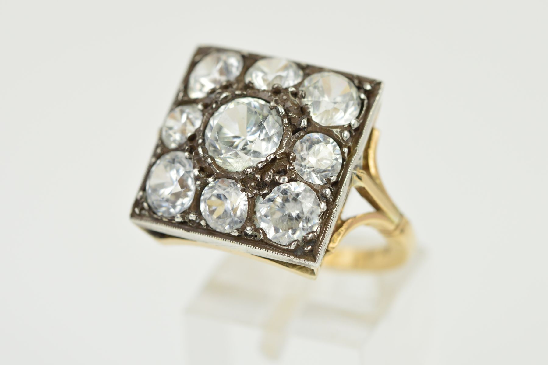 AN EARLY 20TH CENTURY LARGE ZIRCON DRESS RING, square head measuring approximately 17.8mm in