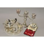 A GEORGE V SILVER THREE PIECE TEA SERVICE, wavy circular form, repousse decorated with birds,