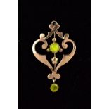 AN EDWARDIAN 9CT GOLD PERIDOT PENDANT, of openwork scrolling design set with a central circular