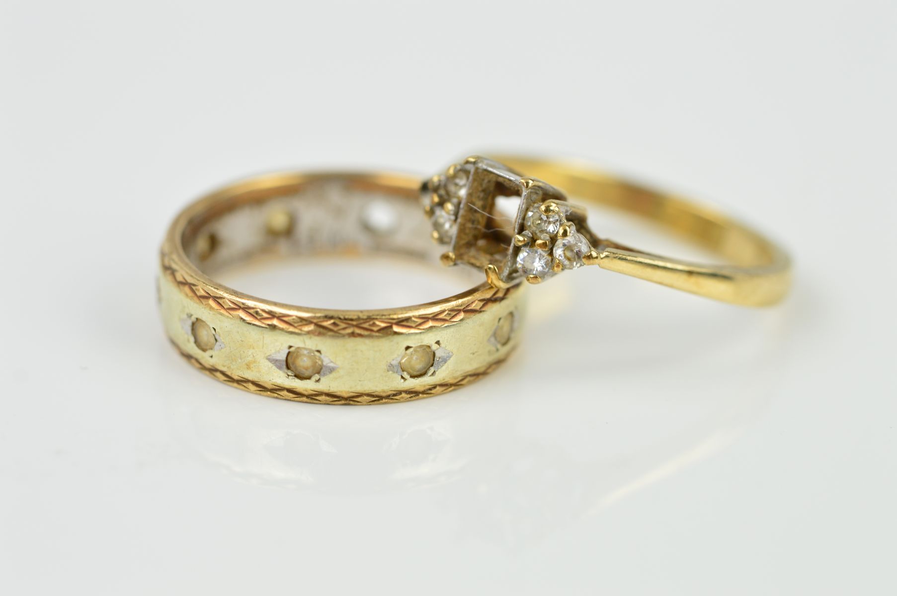 TWO 9CT GOLD RINGS, the first an eternity ring, the central band in a white metal with yellow