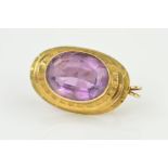 A 9CT GOLD AMETHYST BROOCH/PENDANT, designed as a central oval amethyst within a collet setting to