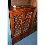 AN OLD CHARM OAK LEAD GLAZED TWO DOOR BOOKCASE above double cupboard doors, width 81cm x depth 28.