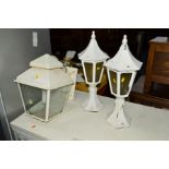 A WHITE PAINTED WROUGHT IRON WALL MOUNTED LANTERN together with a pair of pillar top lanterns (3)