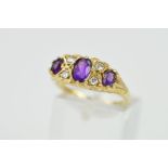 A 9CT GOLD RING, the boat shape panel set with three graduated oval amethysts interspaced by four