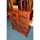 A REPRODUCTION MAHOGANY GLAZED TWO DOOR BOOKCASE on a sloped base with two drawers, width 93cm x