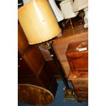 AN EDWARDIAN BRASS COLUMN STANDARD LAMP on square base and four claw feet, with a shade