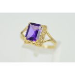 A 9CT GOLD AMETHYST RING, the square amethyst within a four claw setting and openwork gallery,