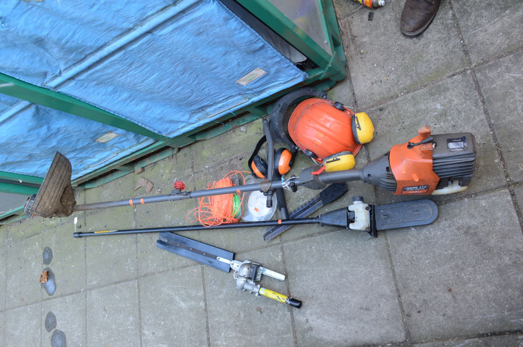 A FLYMO XLT 3000 PETROL GARDEN MULTI TOOL with various attachments including a garden trimmer, extra