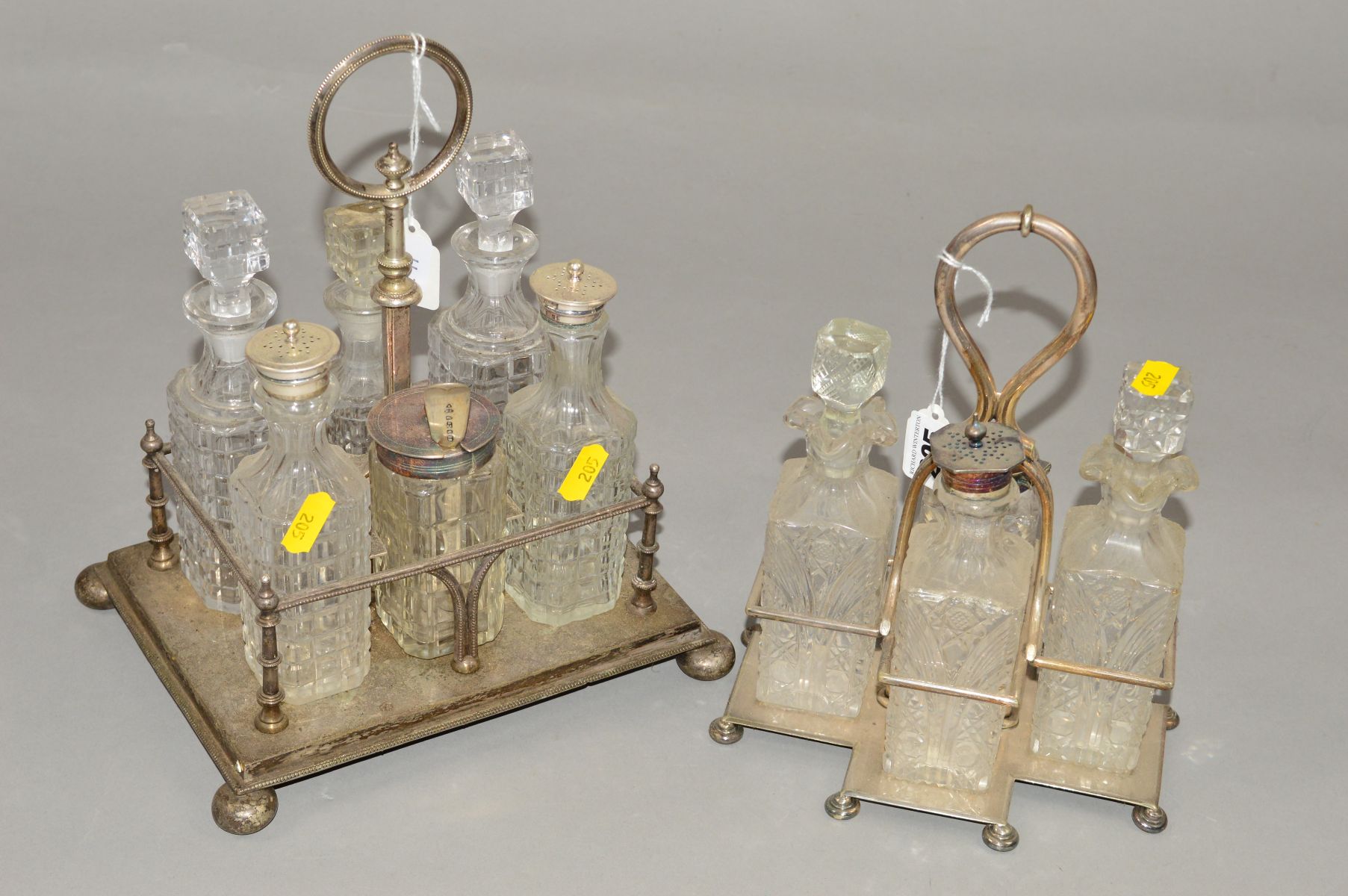 TWO SILVER PLATED AND GLASS BOTTLE CRUETS, one containing four bottles, the other with six