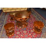 A NOVELTY STAINED CARVED HARDWOOD CIRCULAR COFFEE TABLE AND FOUR MATCHING STOOLS, in the form of