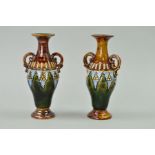 A PAIR OF SMALL DOULTON LAMBETH TWIN HANDLED VASES, brown and green glazes, impressed mark and No.