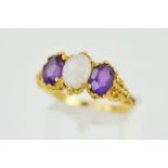 A 9CT GOLD GEM RING, designed as a central oval opal cabochon flanked by oval amethysts, all