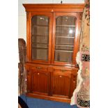 A VICTORIAN WALNUT GLAZED TWO DOOR BOOKCASE, the double doors revealing adjustable shelving, above