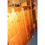 A MODERN PINE SEVEN PIECE BEDROOM SUITE, comprising two double door wardrobes, chest of six drawers,