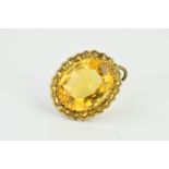 AN EARLY 20TH CENTURY CITRINE PENDANT, the oval faceted citrine within a flower shaped surround,