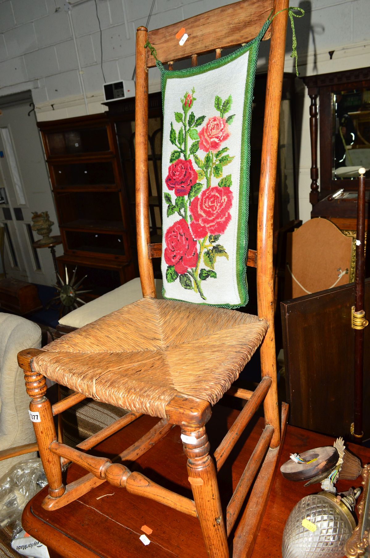 A GEORGIAN ELM RUSH SEATED HIGH BACK ROCKING CHAIR