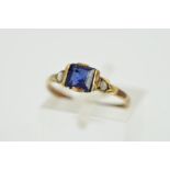 A GEM RING, designed as a central square blue gem flanked by an imitation split pearl and a split