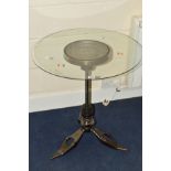 AN INDUSTRIAL CIRCULAR GLASS TOPPED TABLE, on base formed from engine parts, diameter 64cm x