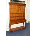A TITCHMARSH & GOODWIN STYLE OAK DRESSER, the top with triple plate rack above three drawers, turned