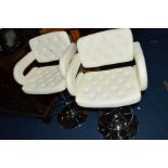 A PAIR OF WHITE BUTTONED LEATHERETTE SWIVEL BAR STOOLS, on chrome bases