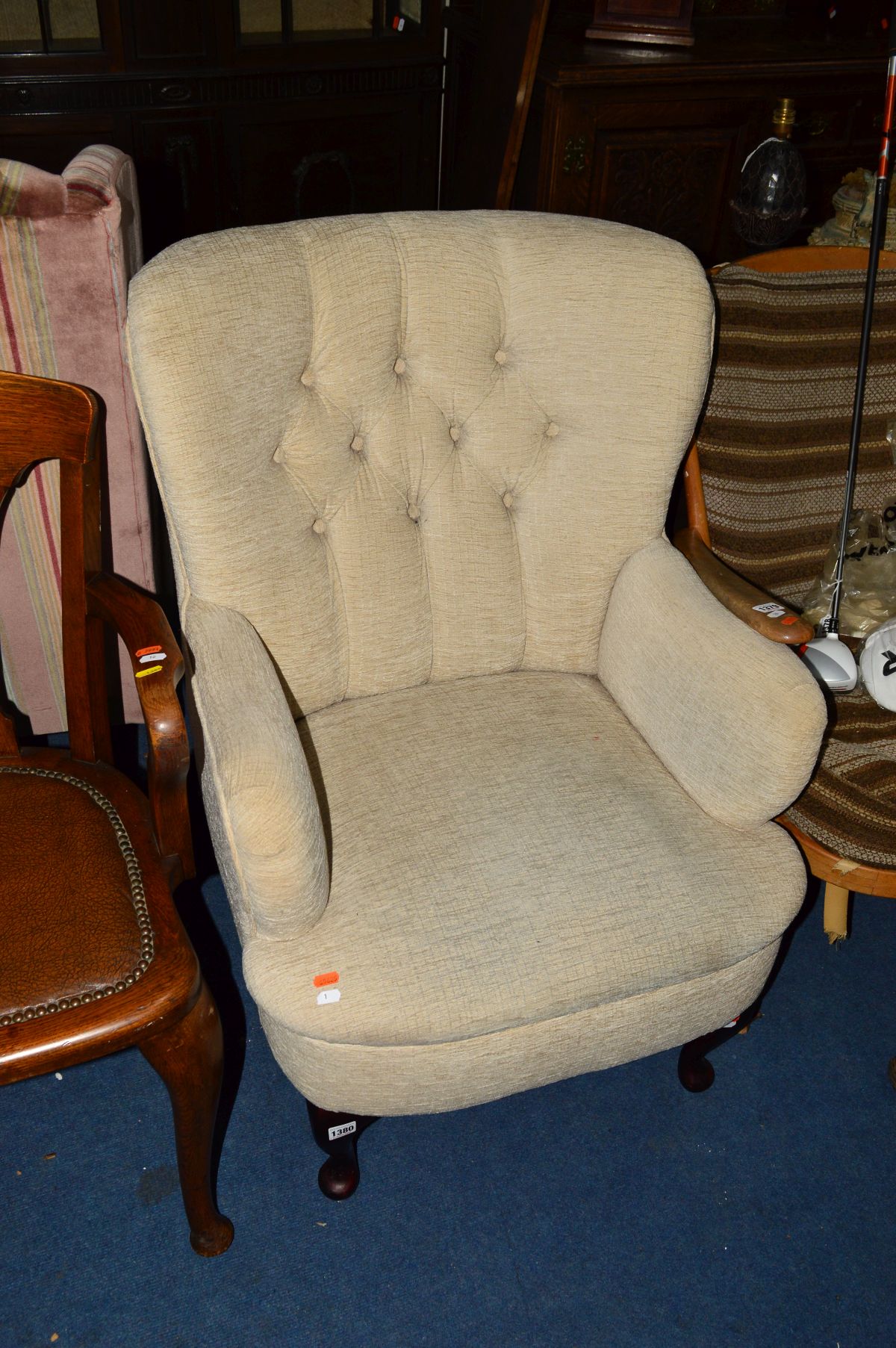 A MODERN OATMEAL UPHOLSTERED ARMCHAIR, with a buttoned back