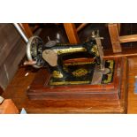 AN OAK TREADLE SINGER SEWING MACHINE, containing sewing accessories