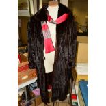 A MINK COAT, designed with a lapel collar, rolled cuffs, three hook and eye fastenings, inner ribbon