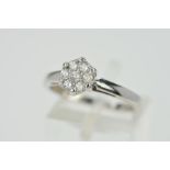 A DIAMOND DRESS RING, designed as circular panel set with seven brilliant cut diamonds, stamped