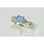 A TOPAZ AND DIAMOND RING, designed as a central square blue topaz with triangular detail to the